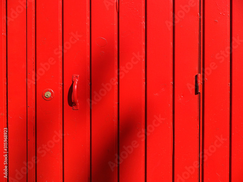 Puerta metálica roja cerrada con cerradura y asa © Juanmi