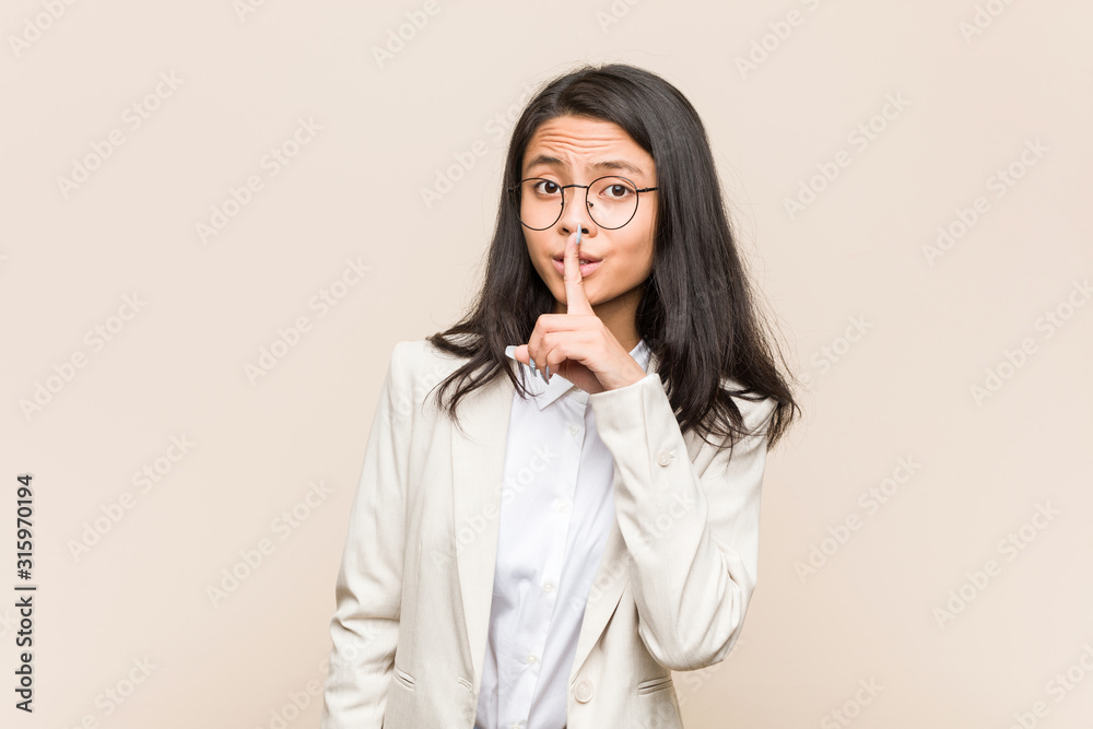 Young business chinese woman keeping a secret or asking for silence. Young business chinese woman keeping a secret or asking for silence.