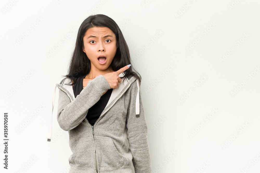 Young fitness chinese woman pointing to the side Young fitness chinese woman pointing to the side