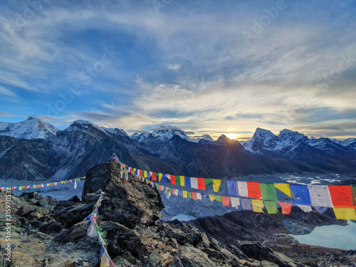 Picturesque view on Everest, Nuptse, Cholatse mountains and buddhist colorful praying flags. At the top of Gokyo Ri at sunrise. Trekking in Solokhumbu, Nepal, Himalayas.
