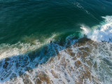 Surfers on a wave from an aerial perspective