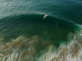 Surfers on a wave from an aerial perspective