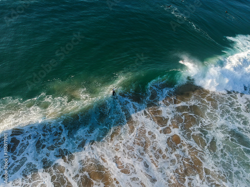 Fototapeta Naklejka Na Ścianę i Meble -  Surfers on a wave from an aerial perspective