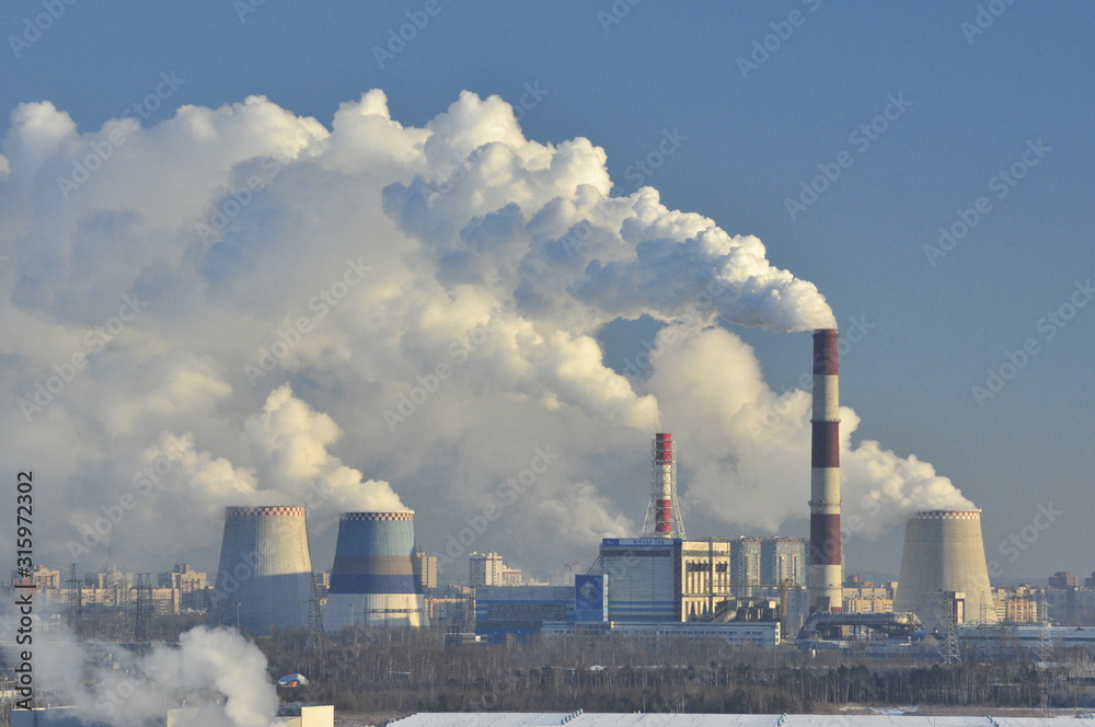 Thermal power station, white smoke, blue sky background, frosty. Environmental pollution.