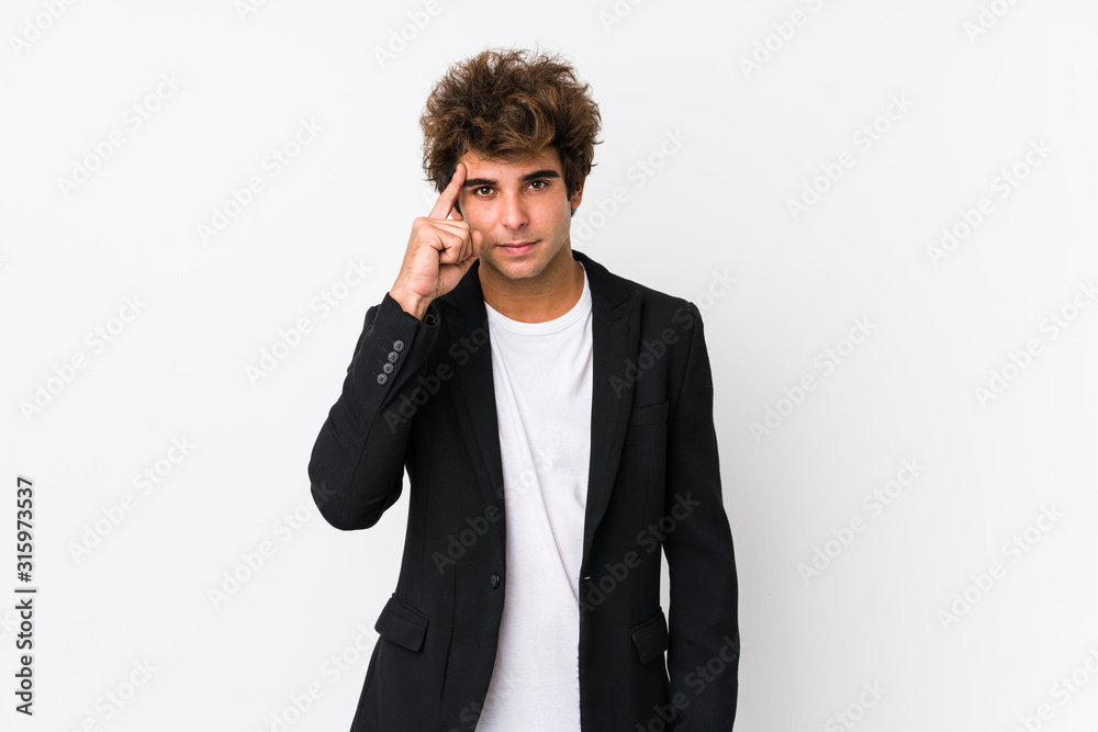 Young caucasian business man against a white background isolated pointing temple with finger, thinking, focused on a task. Young caucasian business man against a white background isolated pointing temple with finger, thinking, focused on a task.