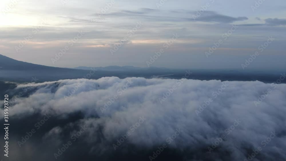 Cinematic 4k aerial video with smooth motion of thick clouds on Bali, Indonesia with mount Agung in the background