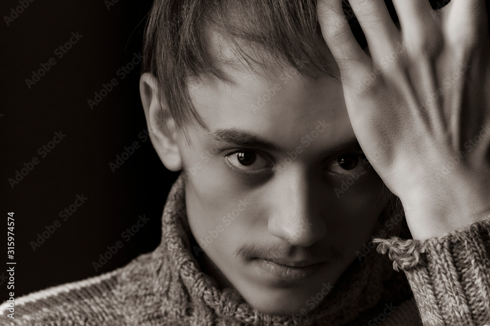 A young guy with a fashionable hairstyle poses for the camera A young guy with a fashionable hairstyle poses for the camera