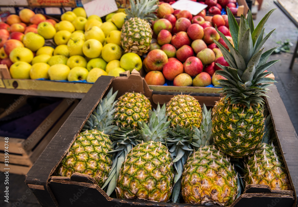 Fresh fruits pineapples and apples on the local sicilian market in Italy