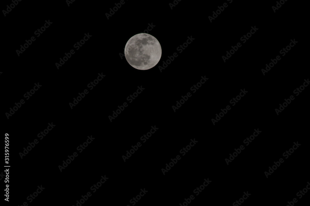 Full moon pictured against cloudy night sky
