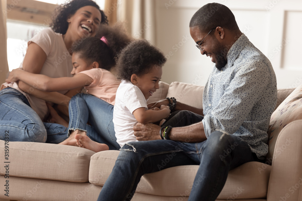 Happy black family with children tickling each other. Happy black family with children tickling each other.
