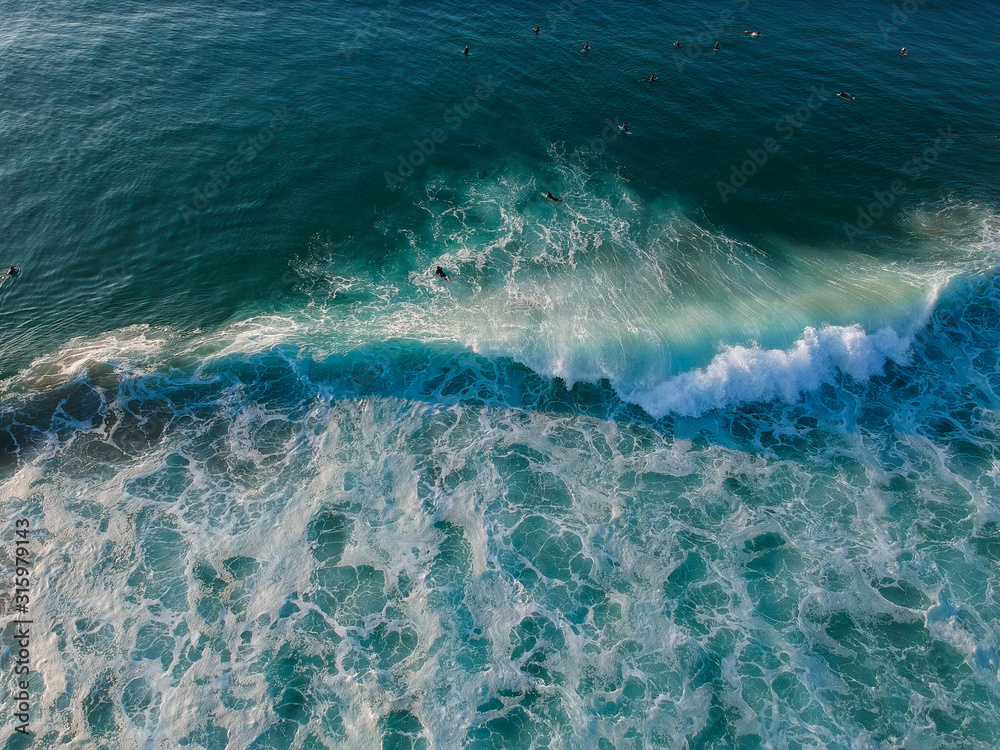 Aerial view of surfers and big wave in the ocean. Top view