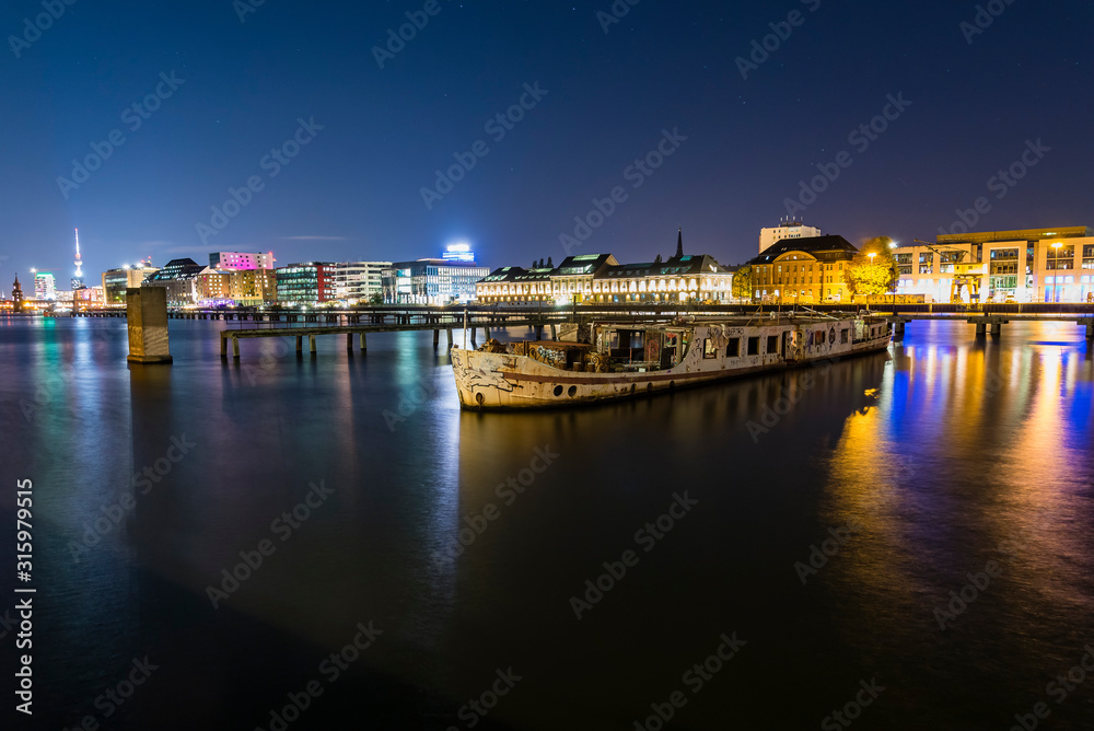 Old big boat that ran aground, an old boat lies on the ground, night shot, colorful, Berlin, Treptow harbor