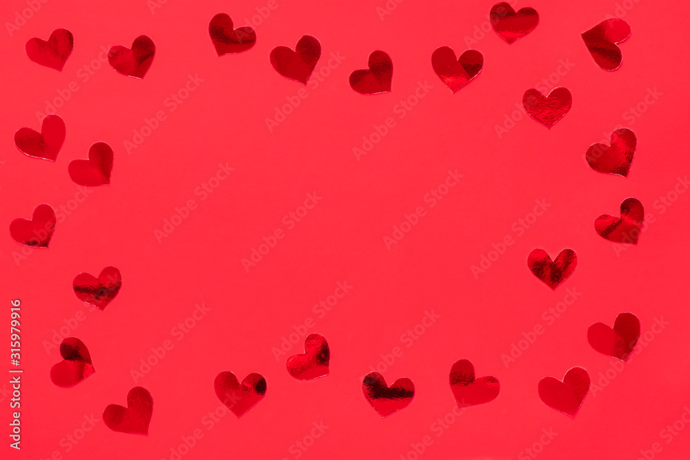 Frame made of red shiny hearts on red background