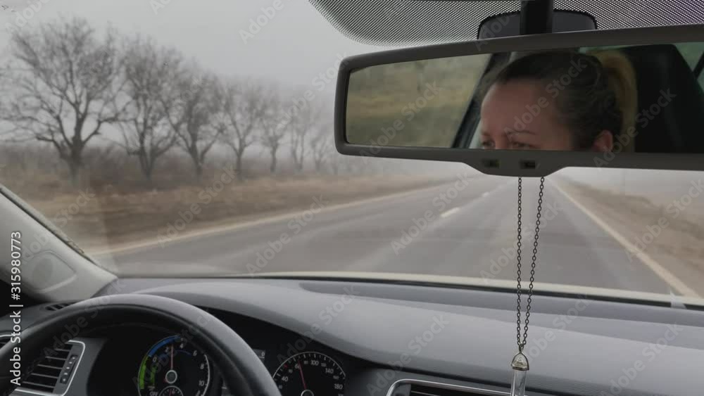 Woman driving the car, mirror view. Woman driving the car, mirror view.