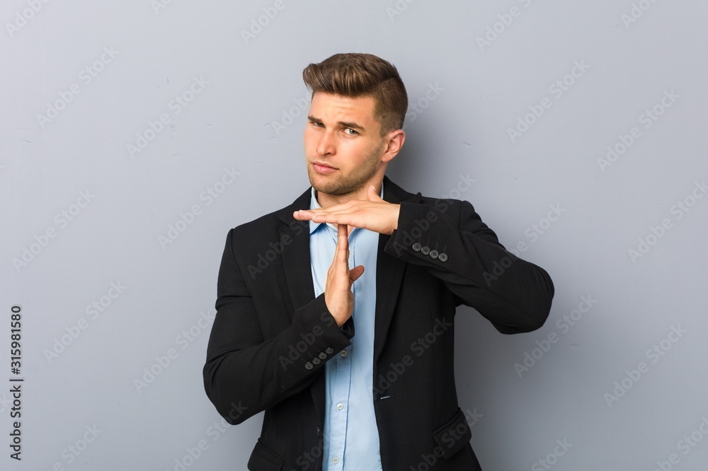 Fotografie Young handsome caucasian man showing a timeout gesture.