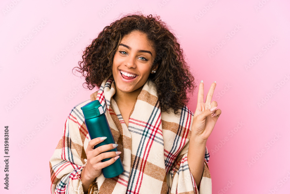 Young african american woman resting in a camping isolated joyful and carefree showing a peace symbol with fingers. Young african american woman resting in a camping isolated joyful and carefree showing a peace symbol with fingers.