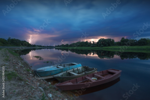 A lot of lightning over the river, in the foreground of the boat.