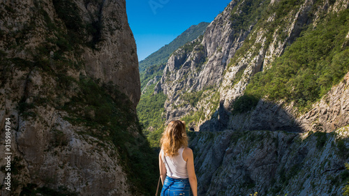 Beautiful, slender girl looks at the mountains and canyon in Montenegro. © velitchenko