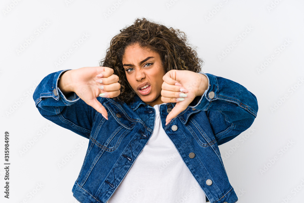 Young african american woman showing thumb down and expressing dislike. Young african american woman showing thumb down and expressing dislike.