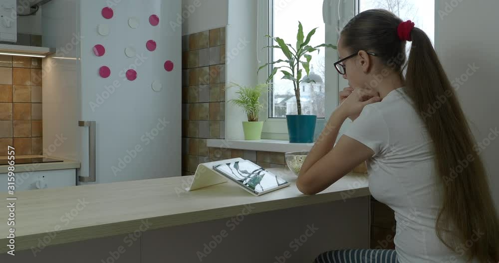 Teenager girl looking series on the tablet and eating popcorn Teenager girl looking series on the tablet and eating popcorn