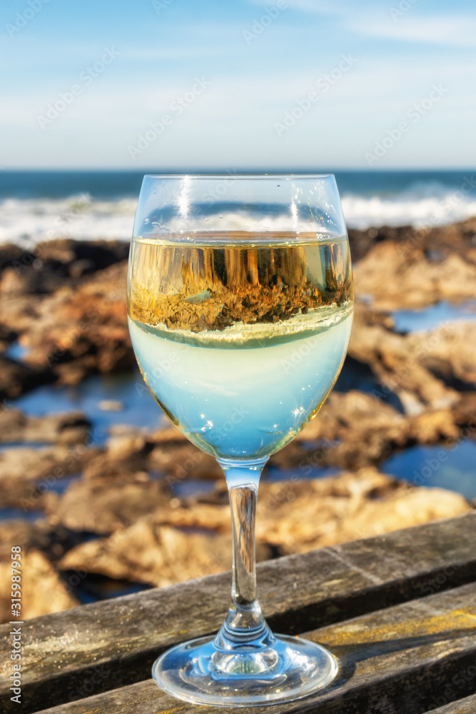 glass of white wine on the beach