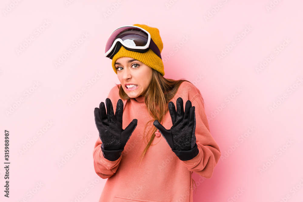 Young caucasian woman wearing a ski clothes isolated rejecting someone showing a gesture of disgust.