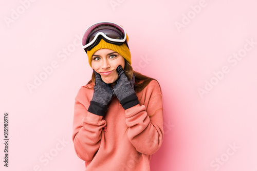 Young caucasian woman wearing a ski clothes isolated doubting between two options. © Asier