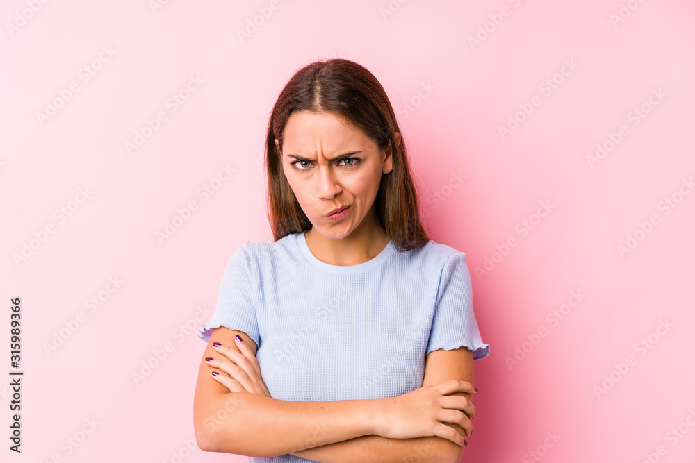 Fototapeta premium Young caucasian woman wearing a ski clothes isolated frowning face in displeasure, keeps arms folded.