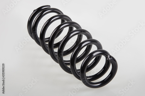 New black metal shock spring isolated on white background. Car spare parts