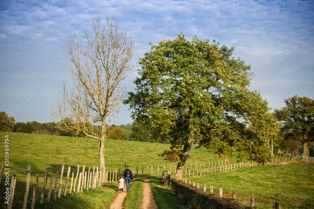 Φωτογραφία petite fille et sa maman se promenant sur un chemin à la campagne