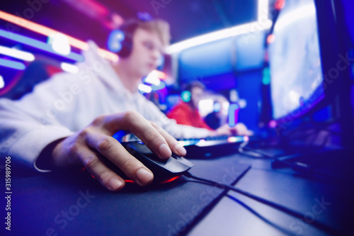 Professional gamer playing tournaments online video games computer with headphones, red and blue