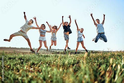 Happy young people jumping in mountains.