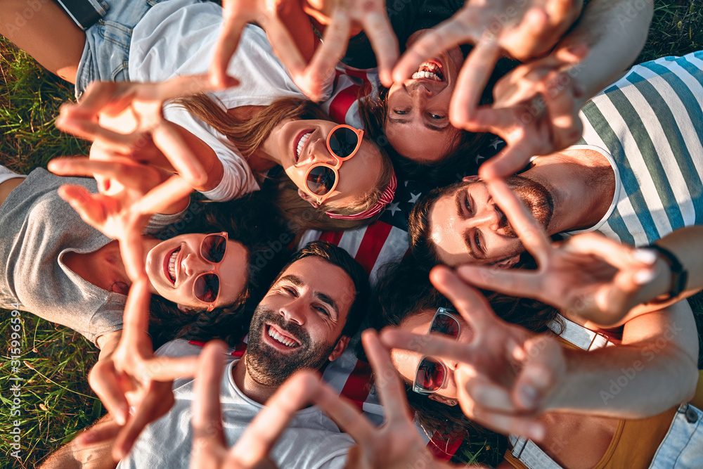 Obraz premium Young cheerful people enjoying on summer meadow