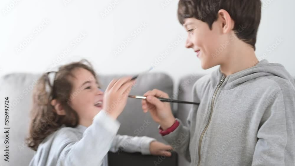 brothers playing with temper in white background. Boy of eight years old and girl of three years old getting dirty. brothers playing with temper in white background. Boy of eight years old and girl of three years old getting dirty.