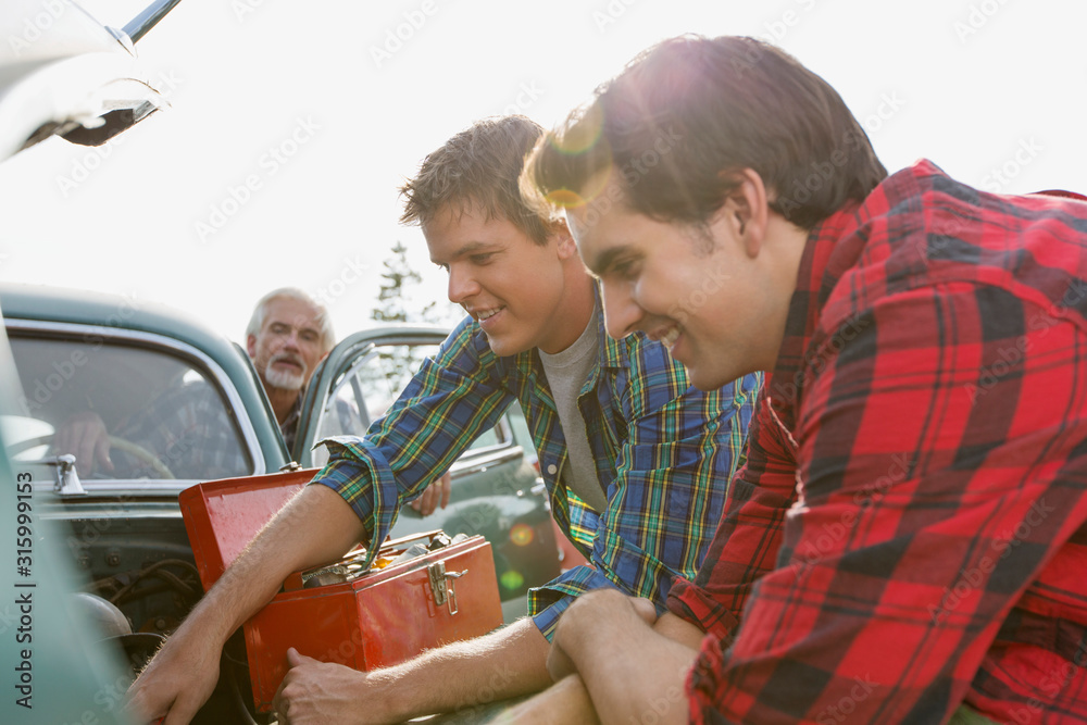 Brothers helping father to repair old car. Stock Photo | Adobe Stock