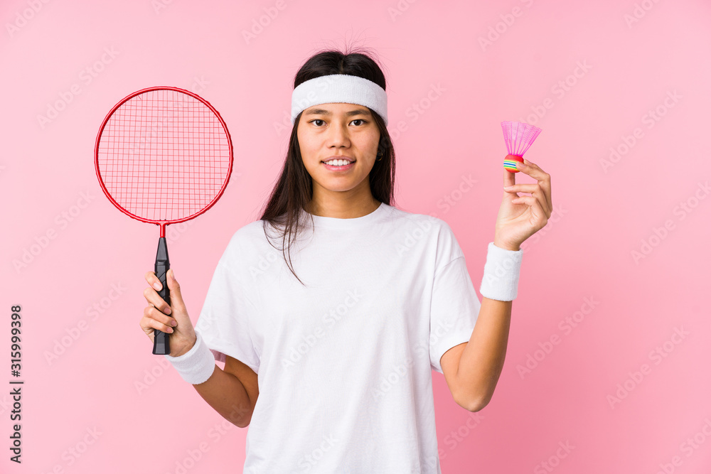 Young chinese woman playing badminton isolated Young chinese woman playing badminton isolated