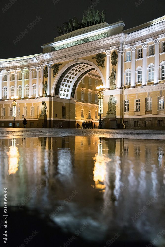 Triumphal arch of the General staff building in Saint Petersburg, Russia. Ancient architecture of Saint Petersburg. Reflection in the water. Rainy day.