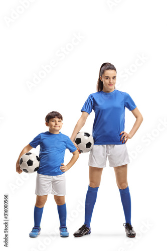 Boy and young female in sports jersey holding soccer balls