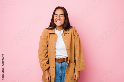 Young mixed race indian woman isolated laughs and closes eyes, feels relaxed and happy.