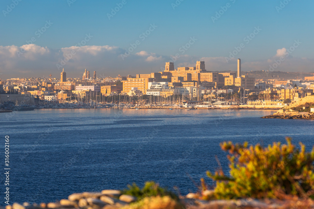 Iddylic scenery of the coastline of Malta at sunrise with Gzira city.