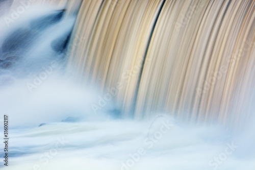 Landscape captured with blurred motion of a cascade on the Rabbit River, Michigan, USA