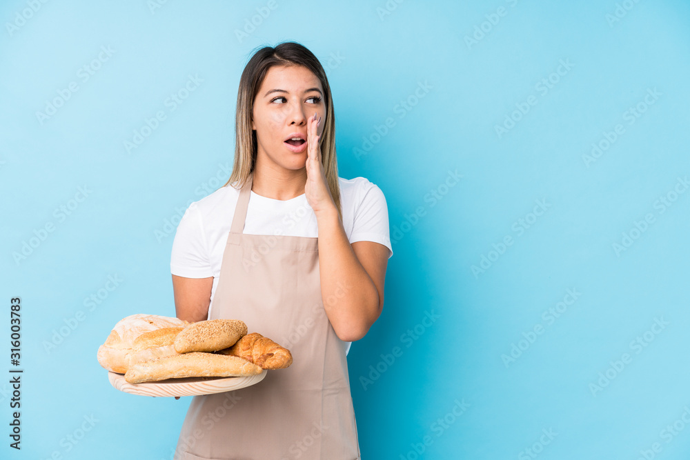 Young caucasian baker woman isolated is saying a secret hot braking news and looking aside Young caucasian baker woman isolated is saying a secret hot braking news and looking aside