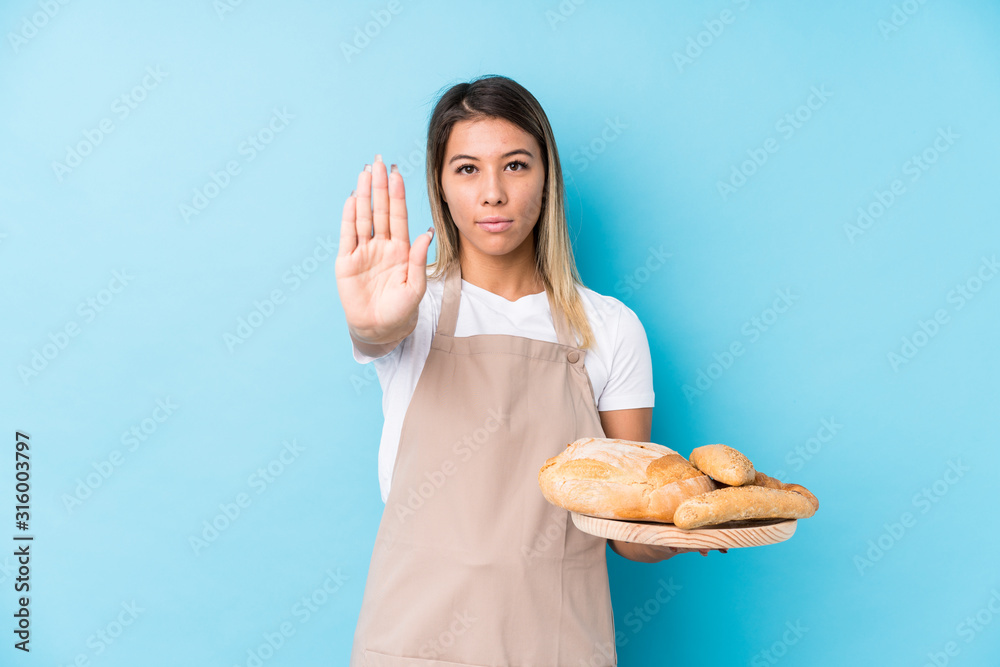 Young caucasian baker woman isolated standing with outstretched hand showing stop sign, preventing you. Young caucasian baker woman isolated standing with outstretched hand showing stop sign, preventing you.