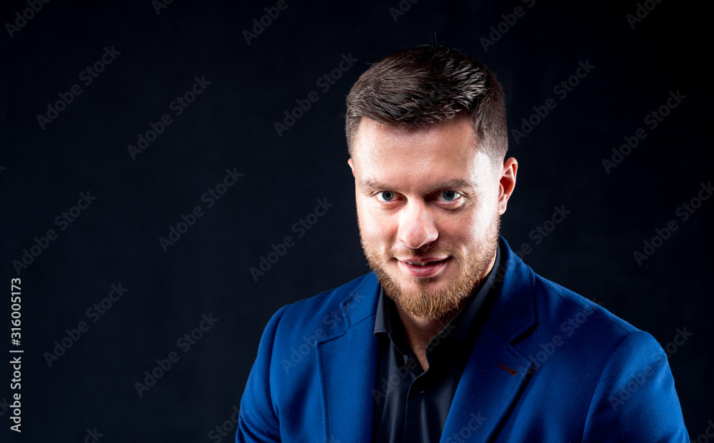 Attractive young guy posing in studio. Portrait of a handsome man with light beard and nice face. Confident look to the camera. Horizontal portrait