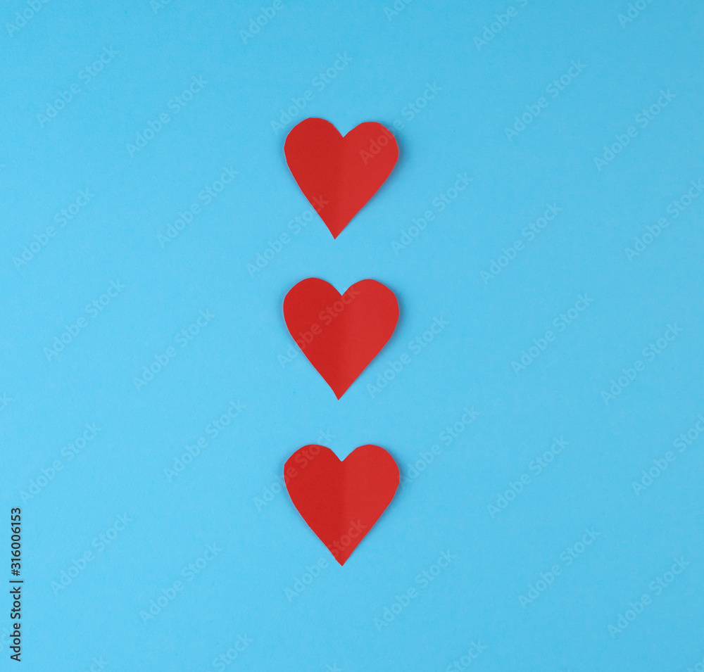 hearts cut out of red paper on a blue background, festive backdrop hearts cut out of red paper on a blue background, festive backdrop