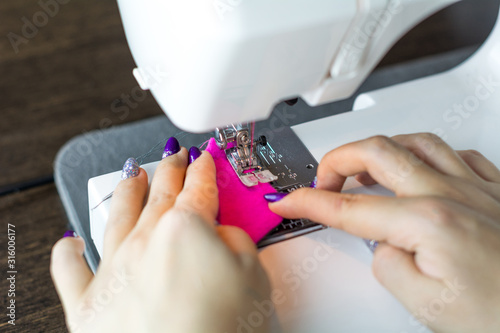 Closeup of a young woman's hands sewing with a sewing machine