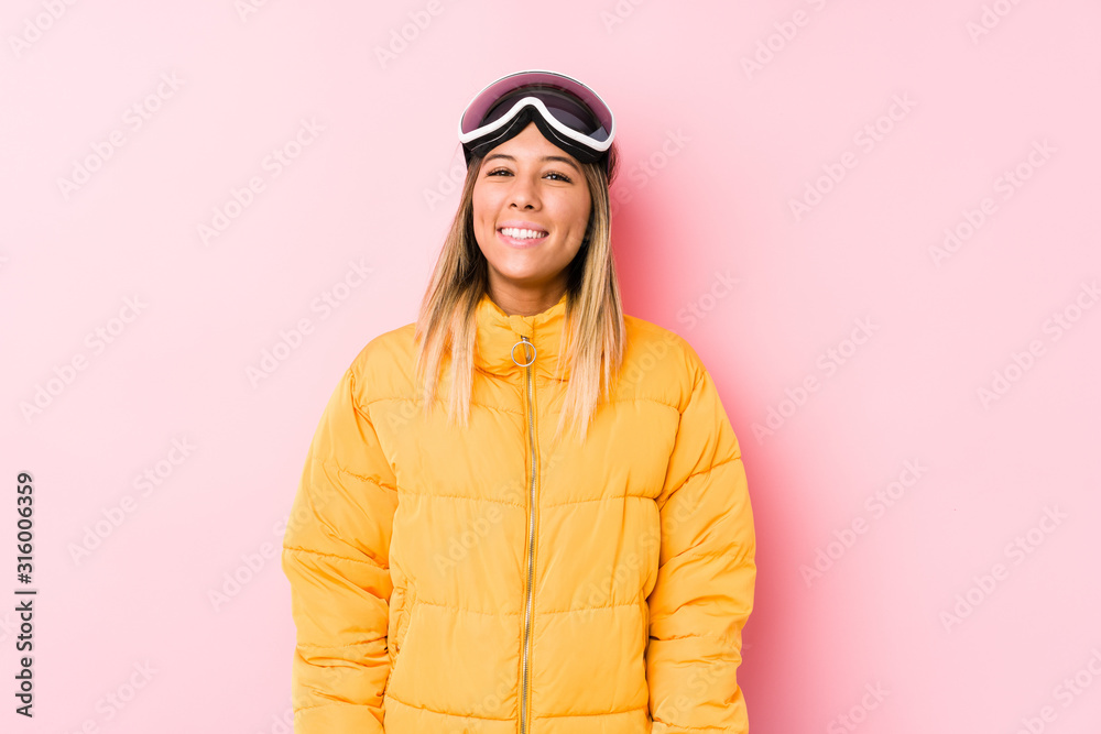 Young caucasian woman wearing a ski clothes in a pink background happy, smiling and cheerful. Young caucasian woman wearing a ski clothes in a pink background happy, smiling and cheerful.