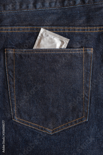 Obraz na płótnie Condom package in the back pocket of dark blue jeans. Protected sex and health care concept. Copy space. Closeup w salonie
