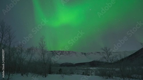 Aurora lights in cold winter, arctic green northern lights. Colour northern lights dancing in dark skies. Burning bright brilliant aurora and stars run through the sky. Time lapse clip. Full HD.