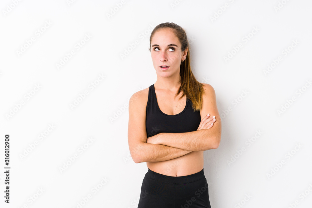 Young caucasian fitness woman posing in a white background tired of a repetitive task. Young caucasian fitness woman posing in a white background tired of a repetitive task.